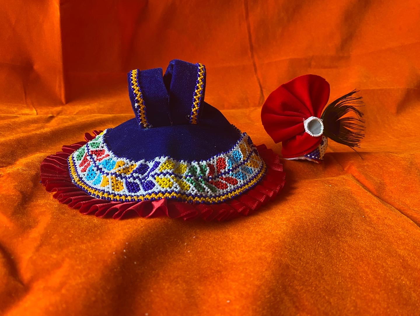 Laddu Gopal dress set with blue beaded outfit and red frills with red turban on orange fabric